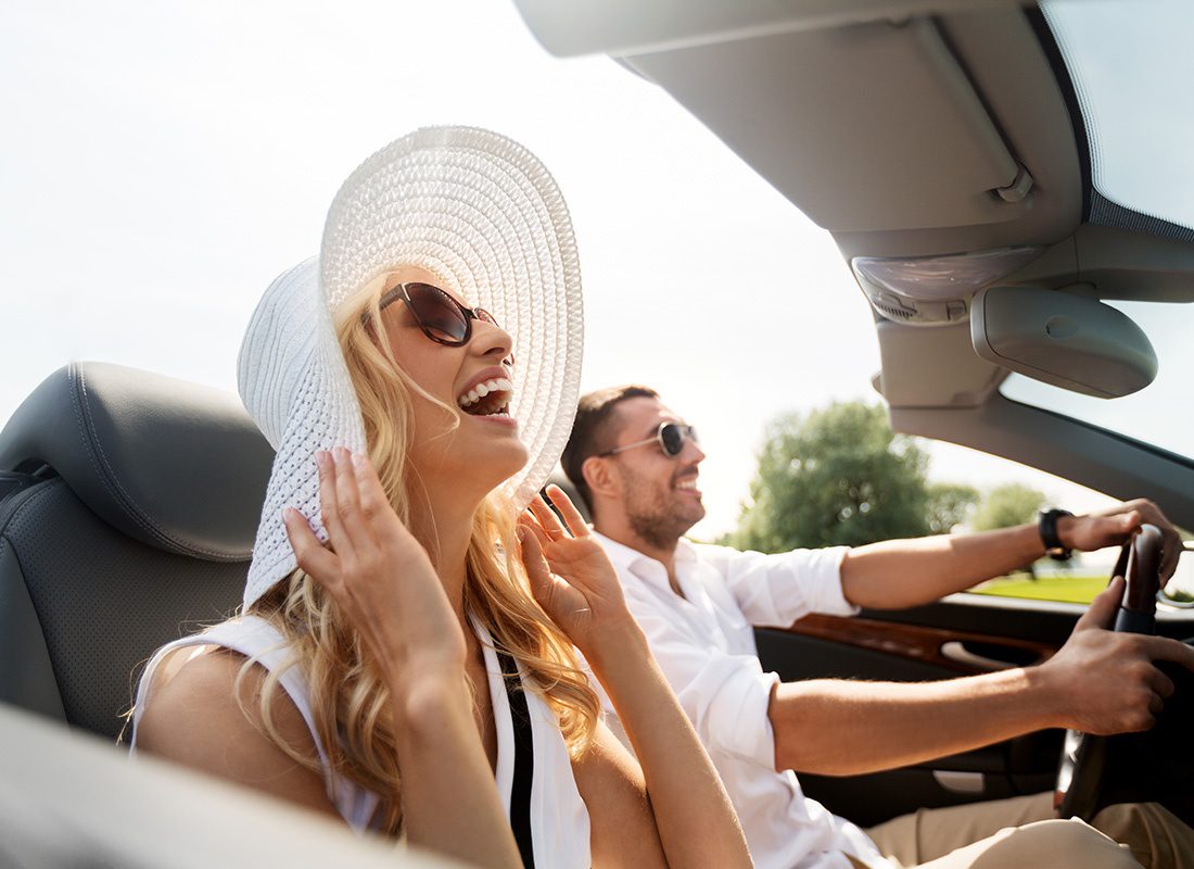 Personal Insurance - A Happy Man and a Happy Woman Taking a Leisure Drive in a Cabriolet Car on a Nice Sunny Day